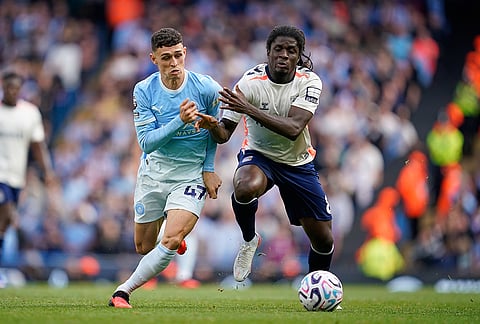 Coventry City's Caleb Yirenkyi, right, challenges for the ball with Manchester City's Phil Foden during the English Premier League soccer match between Manchester City and Coventry City in Manchester, England, Saturday, Sept. 5, 2026. 