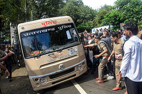A police vehicle tilts during Congress leaders' protest march towards the Uttarakhand CM's residence over an FIR filed against Lok Sabha LoP Rahul Gandhi in Haldwani over the 'purification' row, in Dehradun.
