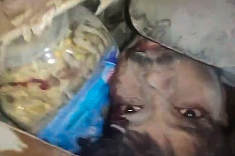 In this image received on Sept. 6, 2026, A person trapped under debris after a 50-year-old five-storey building housing a boys' hostel collapsed in a congested bylane in Satya Niketan near Delhi University’s south campus. Three died in the incident. 