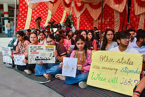 MBBS and BDS interns hold placards as they stage a sit-in protest demanding an increase in their monthly stipend, in Jammu.