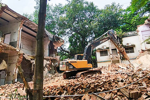 An excavator demolishes the structure of the old Bankipore General Hospital building in the Patna Medical College and Hospital (PMCH) campus, in Patna