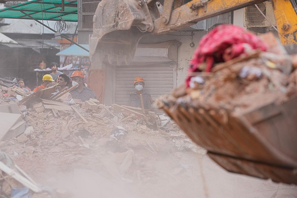 Rescuers clear debris at the site of a collapsed building in New Delhi, India. - | Photo: AP/Manish Swarup