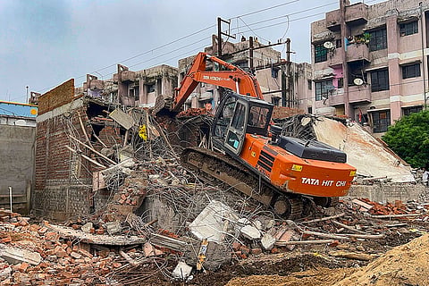 An earthmover demolishes illegal structures as part of an anti-encroachment drive carried out by the Indore Municipal Corporation (IMC), in Indore, Madhya Pradesh.