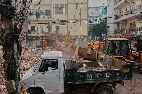 Rescuers clear debris as they search for people possibly trapped at the site of a collapsed building in New Delhi, India.