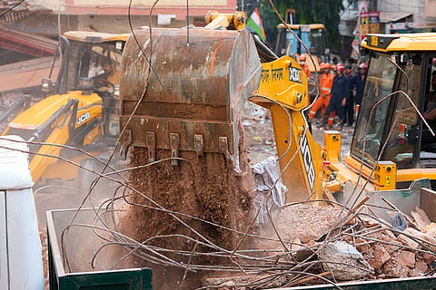 Rescuers clear debris as they search for people possibly trapped at the site of a collapsed building in New Delhi, India.