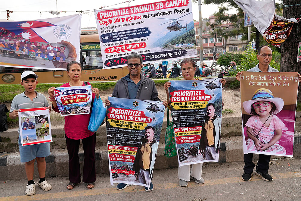 Relatives of recent flash flood victims hold banners urging authorities to step up efforts to find their missing loved ones during a demonstration in Kathmandu, Nepal. - | Photo: AP/Dar Yasin