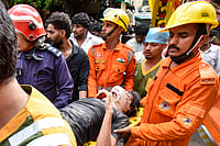 In Photos: Building Collapses In South Delhi's Satya Niketan | Photo: PTI : NDRF, fire department officials carry a rescued person after a 50-year-old five-storey building housing a boys' hostel collapsed in a congested bylane in Satya Niketan near Delhi University’s south campus. Three died in the incident.
