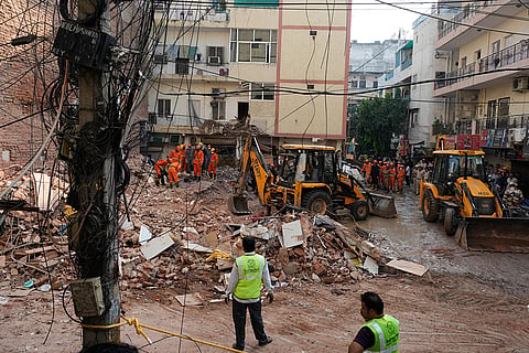 Rescuers clear debris as they search for people possibly trapped at the site of a collapsed building in New Delhi, India.