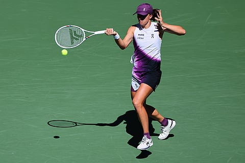 Iga Swiatek, of Poland, returns the ball to Qinwen Zheng, of China, during the fourth round of the U.S. Open tennis championships in New York.