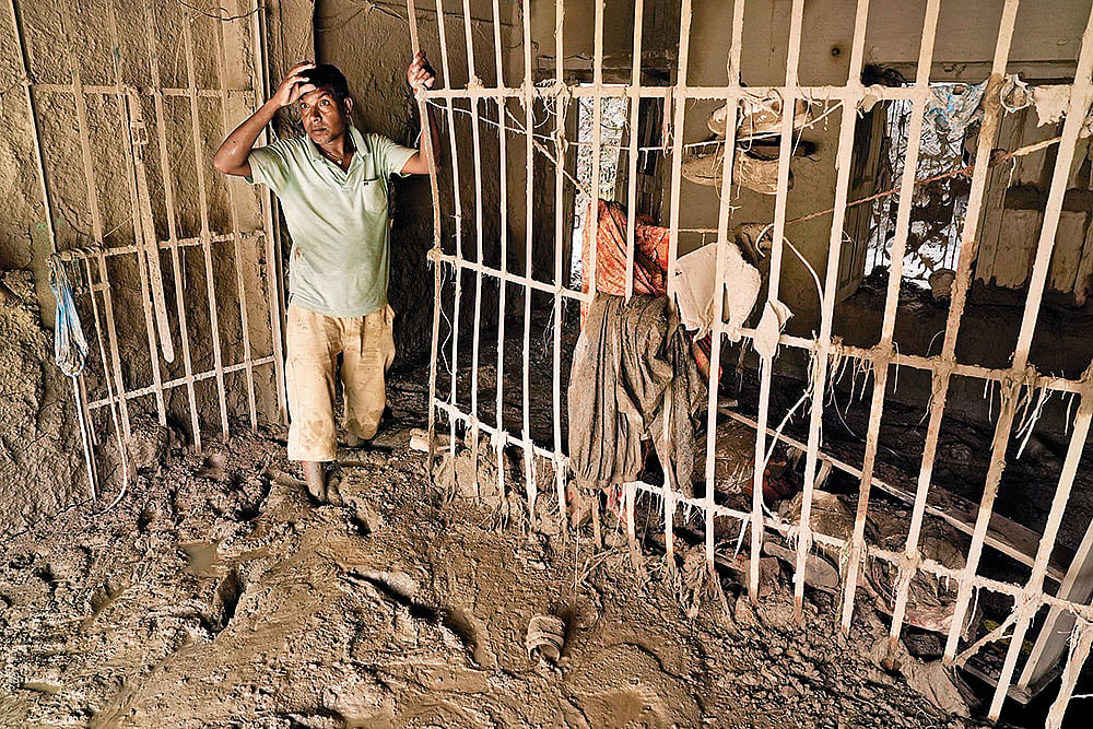 Ashok Sah, a resident of Dhunge Bazar, searches the ruins of his home for anything he can salvage