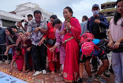 People light candles and pray during a day of mourning for those killed in the Aug. 26 floods in Kathmandu, Nepal, Monday, Sept. 7, 2026. 