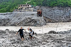 Death and Survival: Rescue workers help people move to safer zones - Photo: AP