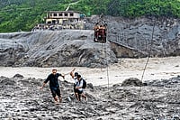 Photo: AP : Death and Survival: Rescue workers help people move to safer zones