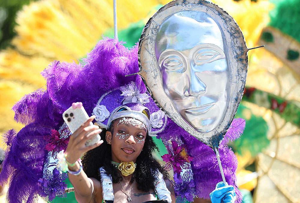 Participants take a selfie as they wait to walk in the West Indian Day Parade on Monday, Sept. 7, 2026, in the Brooklyn borough of New York.  - | Photo: AP/Heather Khalifa