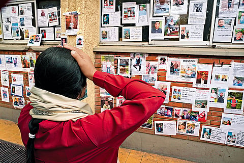 Fading Hope: A woman scans the notice board at Tribhuvan University Teaching Hospital 