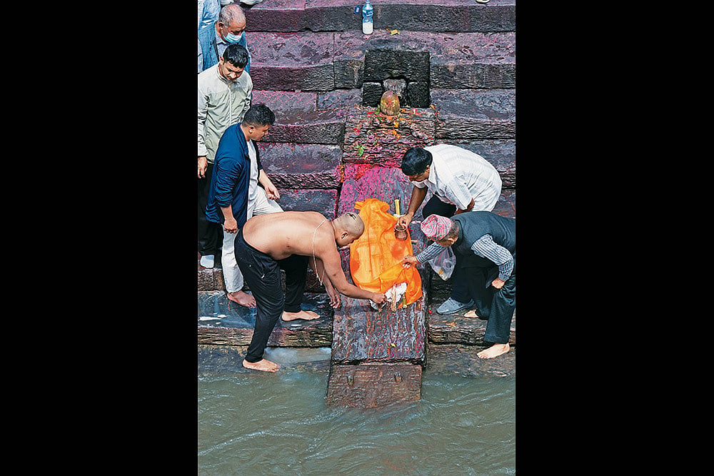 Family members hold a symbolic funeral of a child at Arya Ghat inside Pashupati Nath Temple