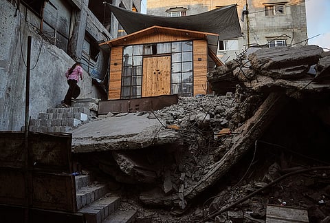 Palestinian youth Julia Joudeh, 11, climbs to her new wooden house, which was built on top of the rubble of her family's home destroyed during the war between Israel and Hamas, in Gaza City, Wednesday, Sept. 2, 2026. 