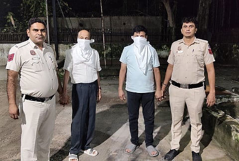 Hariram Gupta, second left, owner of the Satya Niketan building that collapsed on Sunday and claimed the lives of seven people, and his son Mahesh Gupta arrested by police, in New Delhi. 