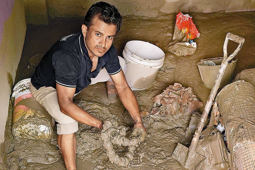 Prem Lamichhane, the owner of a hardware shop, looks for any undamaged goods