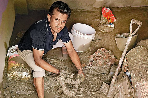 Prem Lamichhane, the owner of a hardware shop, looks for any undamaged goods
