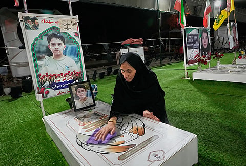 A woman cleans the grave of a child killed in a Feb. 28 U.S. airstrike on Shajareh Tayyebeh school in a section of Minab's cemetery set aside for those killed at the school in southern Iran, Monday, Sept. 7, 2026. 