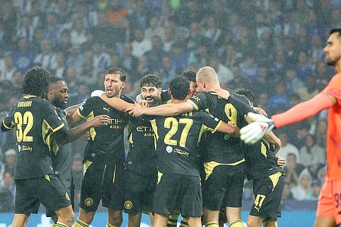 Manchester City players celebrate after Erling Haaland, right, scored the opening goal during a Champions League opening phase soccer match between FC Porto and Manchester City in Porto, Portugal.