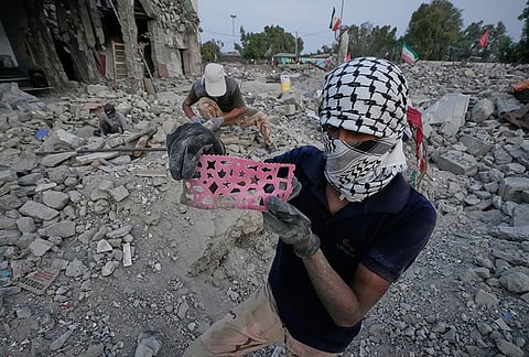 A volunteer shows a child's drawing stencil recovered as volunteers search the rubble of the Shajareh Tayyebeh school, hit on Feb. 28 by a U.S. airstrike in Minab, southern Iran, Monday, Sept. 7, 2026. 