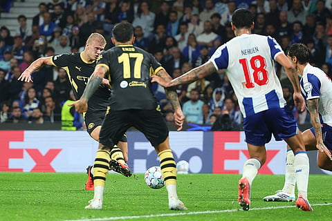 Manchester City's Erling Haaland, left, scores his side's second goal during a Champions League opening phase soccer match between FC Porto and Manchester City in Porto, Portugal.