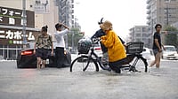 (Natsumi Yasumoto/Kyodo News via AP) : People cross the flooded streets following a heavy rain in Nagoya, central Japan Tuesday, Sept. 8, 2026.
