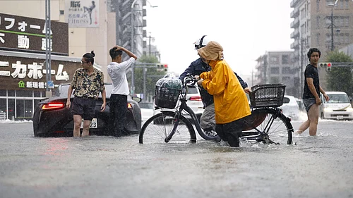 (Natsumi Yasumoto/Kyodo News via AP) : People cross the flooded streets following a heavy rain in Nagoya, central Japan Tuesday, Sept. 8, 2026.