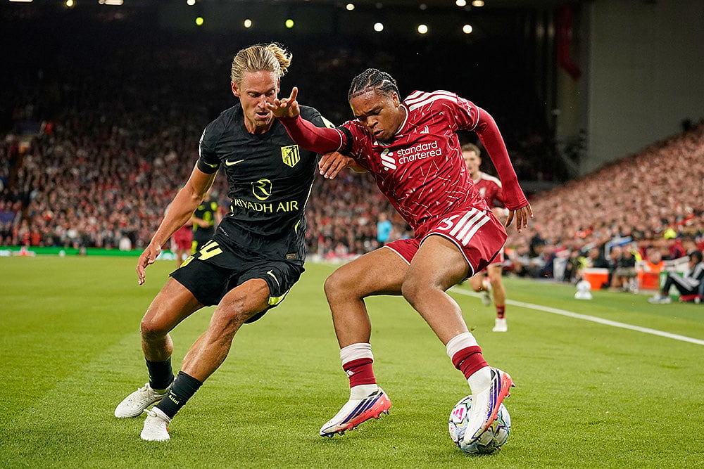 Liverpool's Rio Ngumoha and Atletico Madrid's Marcos Llorente challenge for the ball during the Champions League opening phase soccer match between Liverpool and Atletico Madrid in Liverpool, England. - | Photo: AP/Dave Thompson