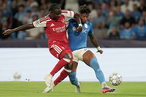 Arsenal's Bukayo Saka, left, and Napoli's Giovane challenge for the ball during their Champions League soccer match between Napoli and Arsenal, in Naples, southern Italy.