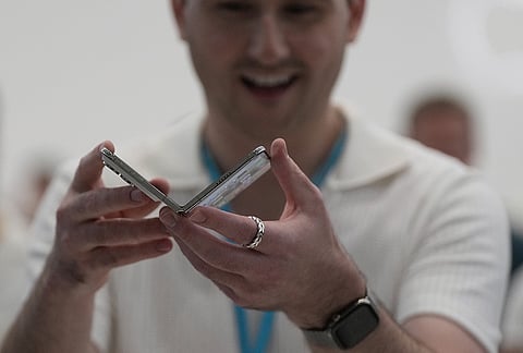 An attendee holds up an iPhone Duo during an announcement of new products on Wednesday, Sept. 9, 2026, on the Apple campus in Cupertino, California. 