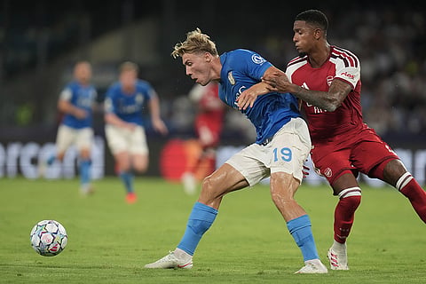 Napoli's Rasmus Hojlund, left, and Arsenal's Ezri Konsa challenge for the ball during their Champions League soccer match between Napoli and Arsenal, in Naples, southern Italy.