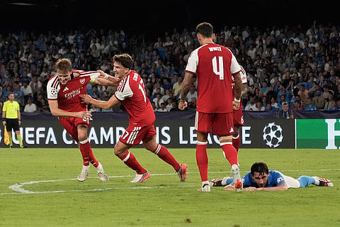 Arsenal's Martin Odegaard, left, celebrates with Arsenal's Christos Tzolis after scoring the opening goal during their Champions League soccer match between Napoli and Arsenal, in Naples, southern Italy.