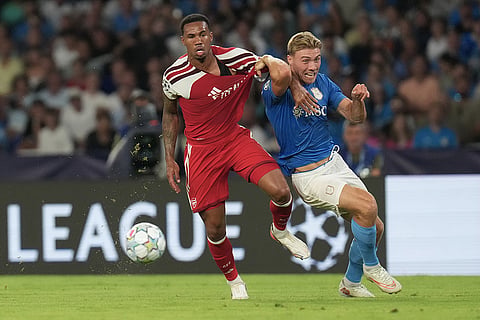 Arsenal's Gabriel, left, and Napoli's Rasmus Hojlund challenge for the ball during their Champions League soccer match between Napoli and Arsenal, in Naples, southern Italy.