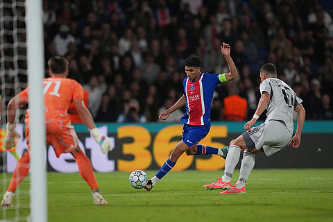 PSG's Achraf Hakimi, center, kicks the ball during the Champions League opening phase soccer match between PSG and Slovan Bratislava in Paris.