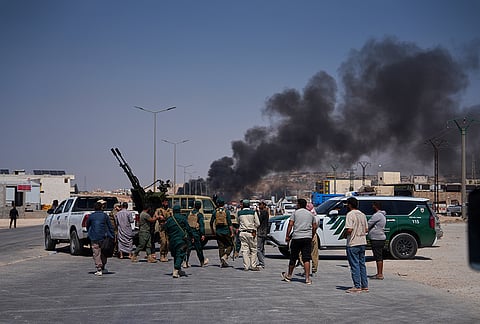 Syrian security forces and others gather as smoke rises after an explosion at what state media said was a weapons depot in the Burj al-Nimra area near Sarmada, in Idlib province, Syria, Wednesday, Sept. 9, 2026.