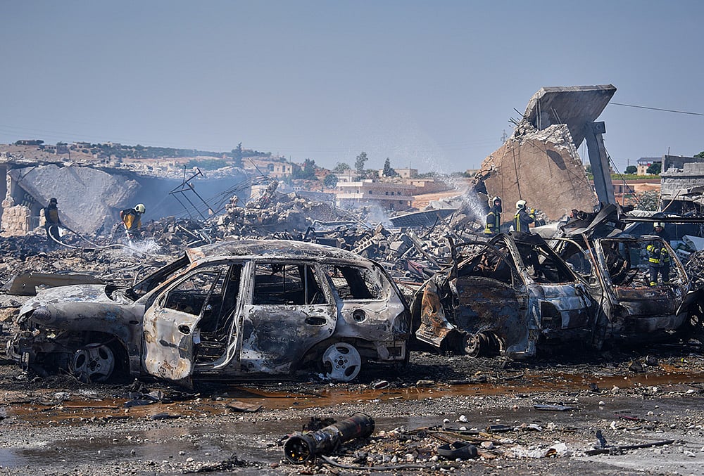 Firefighters work among rubble and burned-out vehicles at the site of an explosion at what Syria's Defense Ministry said was a warehouse used for the temporary storage of weapons near Sarmada, in Idlib province, Syria, Wednesday, Sept. 9, 2026.  - | Photo: AP/Omar Albam