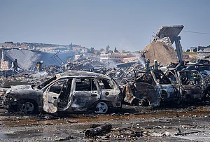 | Photo: AP/Omar Albam : Firefighters work among rubble and burned-out vehicles at the site of an explosion at what Syria's Defense Ministry said was a warehouse used for the temporary storage of weapons near Sarmada, in Idlib province, Syria, Wednesday, Sept. 9, 2026.
