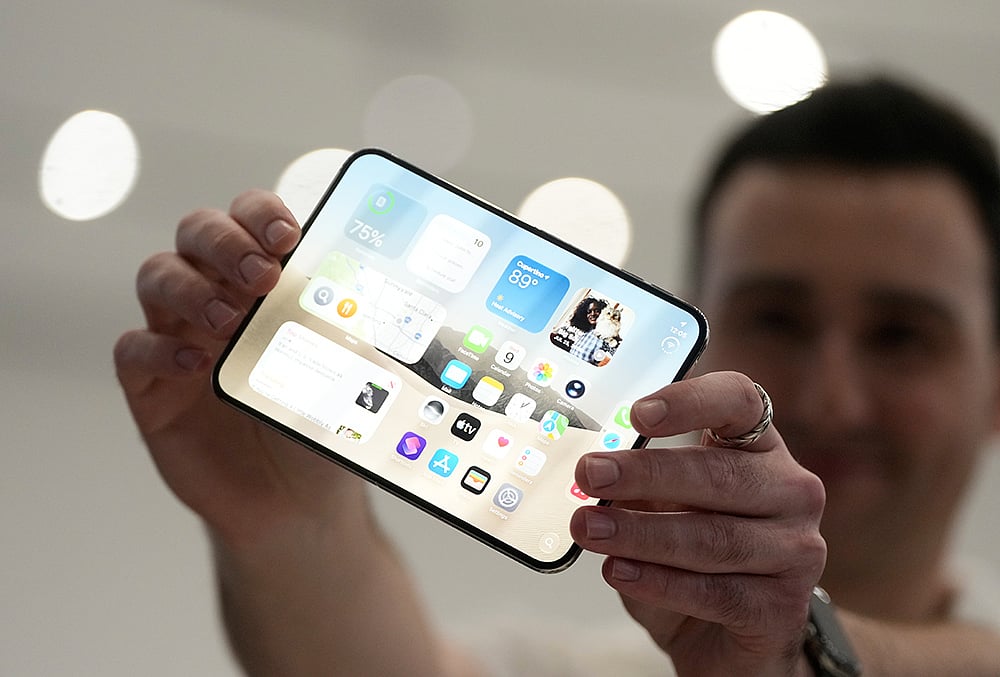 An attendee holds up an iPhone Duo during an announcement of new products on Wednesday, Sept. 9, 2026, on the Apple campus in Cupertino, California.  - | Photo: AP/Jeff Chiu