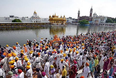 Sikh community members hold swords during a religious procession to observe the 'Guru Granth Sahib Parkash Utsav', marking the 422nd anniversary of the installation of Guru Granth Sahib, in Amritsar.