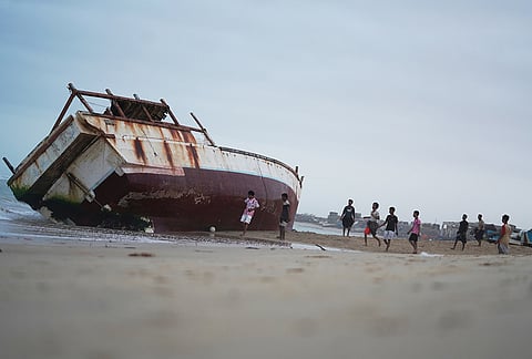 Young men play near a beached fishing boat at a site in Al-Ghaydah district, in Al Mukalla, Yemen, Sunday, Sept. 6, 2026. 