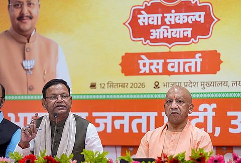 Uttar Pradesh Chief Minister Yogi Adityanath looks on as state BJP President Pankaj Chaudhary addresses a press conference, at party office, in Lucknow.
