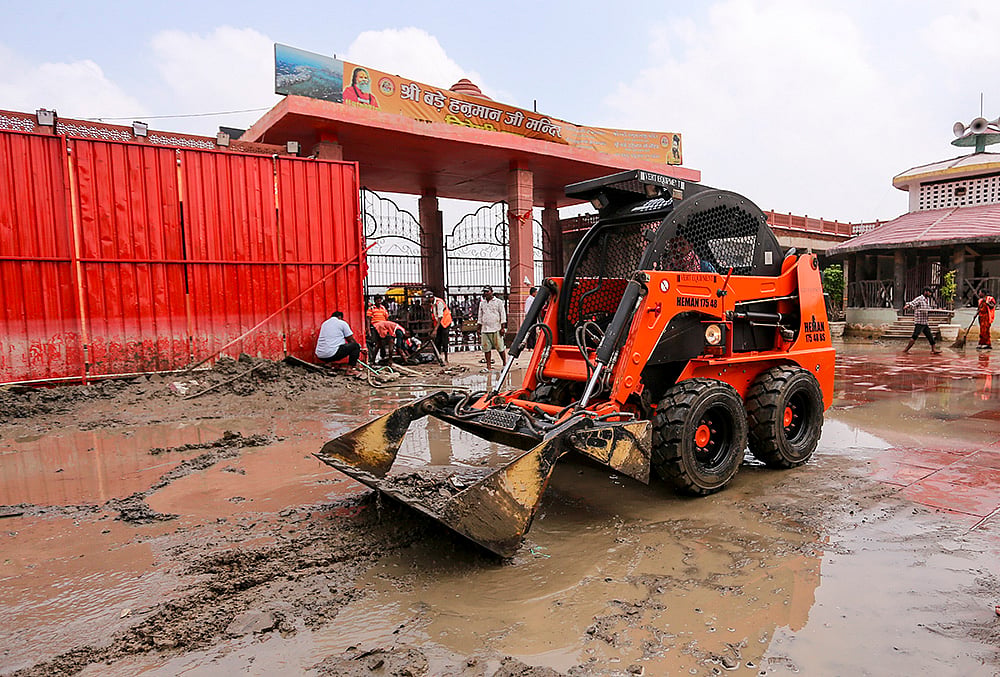 People clean the premises of Bade Hanuman Temple