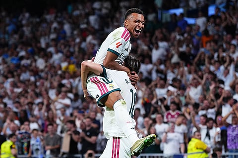 Real Madrid's Alvaro Carreras, bottom, is congratulated by Kylian Mbappe after scoring his side's 2nd goal during the Spanish La Liga soccer match between Real Madrid and Rayo Vallecano in Madrid, Spain.