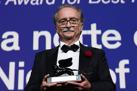 Gian Luca Farinelli poses for photographers after receiving the Venice classics best restored film award for 'Long Night of 1943' during the closing ceremony of the 83rd edition of the Venice Film Festival in Venice, Italy.
