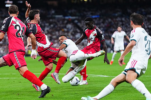Real Madrid's Kylian Mbappe, center, falls on the pitch during the Spanish La Liga soccer match between Real Madrid and Rayo Vallecano in Madrid, Spain.