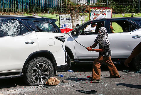 A man attacks a vehicle from an opposing group outside a school used as a polling center during the Bangsamoro Autonomous Region in Muslim Mindanao parliamentary elections in Cotabato city, southern Philippines, Monday, Sept. 14, 2026. 