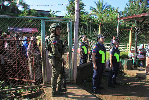 Security forces stand guard at a voting center during the Bangsamoro Autonomous Region in Muslim Mindanao parliamentary elections at a school in Saguiaran, Lanao del Sur province, southern Philippines, Monday Sept. 14, 2026. 